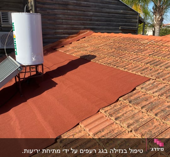 רעפים אדומים על גג עם דוד שמש
